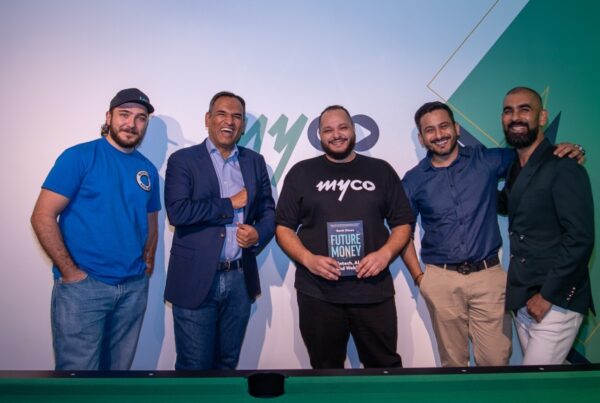 the myco and fumo teams posing together with a copy of the book in front of the myco logo